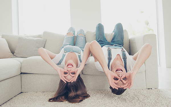 Zwei Jugendliche liegen auf dem Sofa.