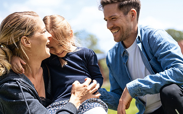 Junge Familie mit Kind im Arm.