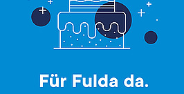 Abbildung einer Geburtstagstorte mit Kerzen, die oben die Zahl 20 bilden. Darunter steht: „Für Fulda da. Seit 20 Jahren.“ Blauer Hintergrund mit kleinen dekorativen Formen.