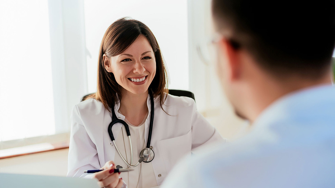 Ärztin berät Patient in Praxis.